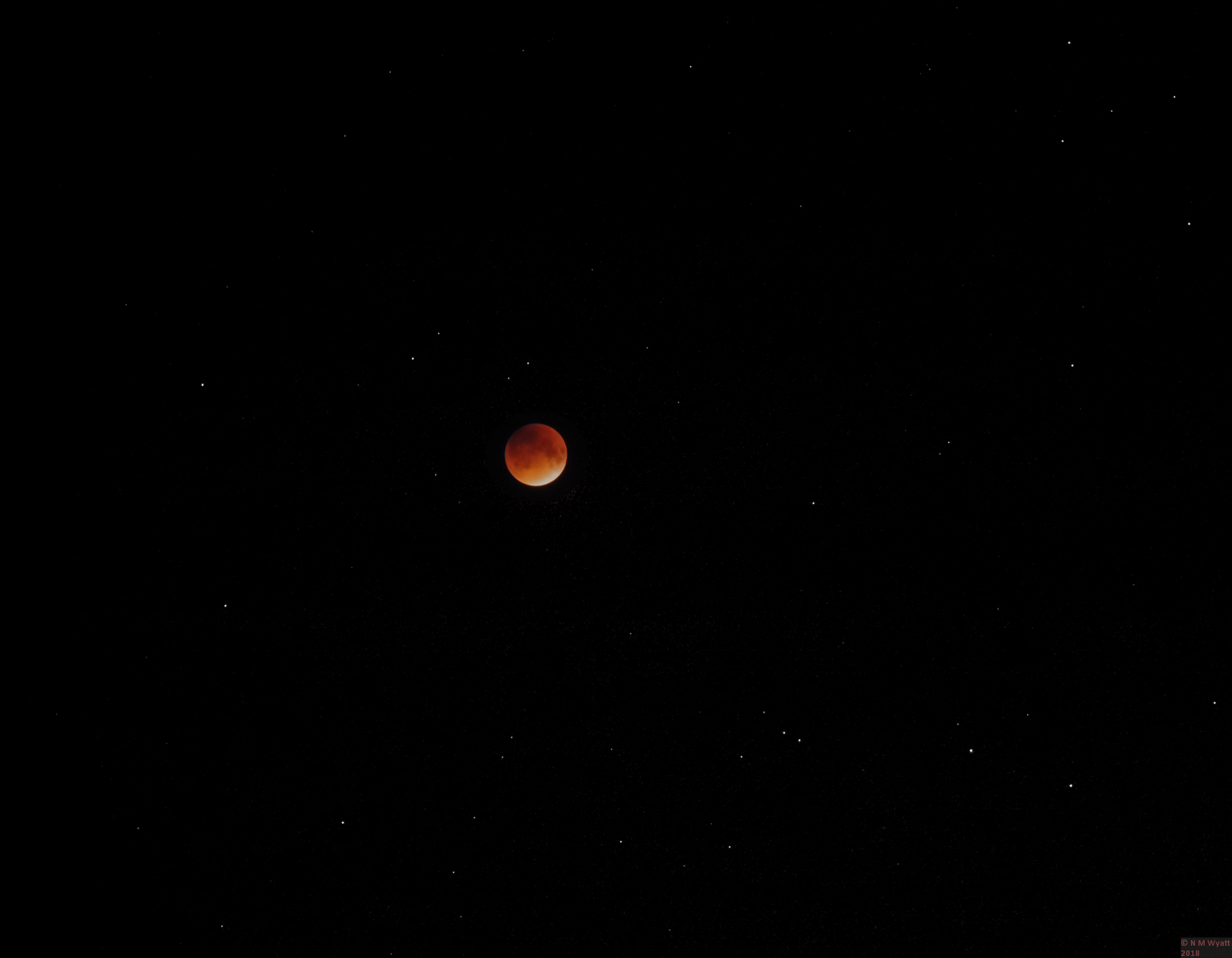 Toatl luner eclipse against a background of scattered stars