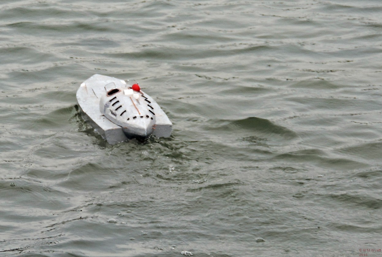 Miss Britain III sails away showing its profusion of pipes and scoops